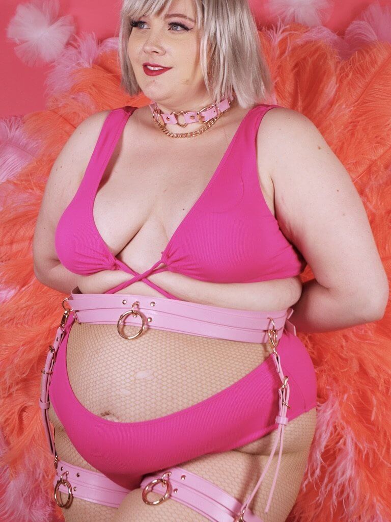 Female model wearing our Candy Pink Zoe Leg Harness with gold hardware.